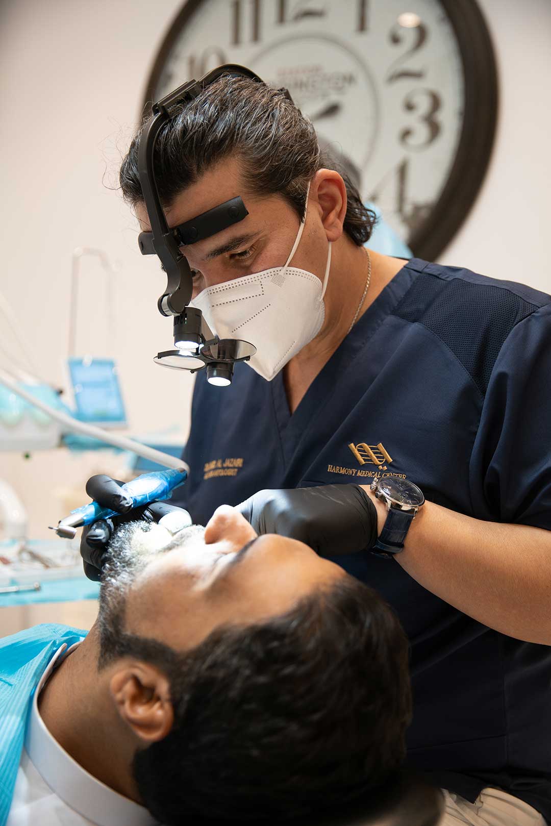 In this photo, Dr. Ahmad Al Jazairi - Medical Director and Head of Oral & Maxillofacial Surgery at Harmony Medical Center, examines a patient for 3D guided dental implant surgery.