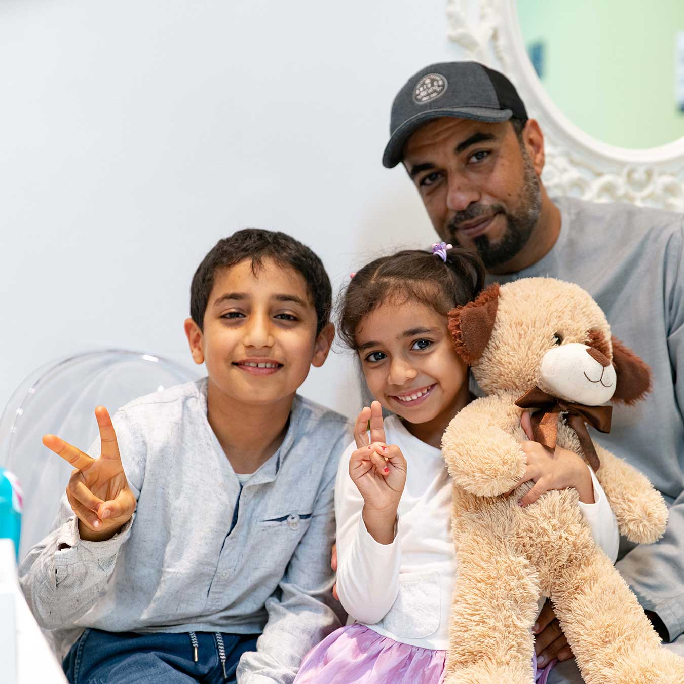 Image of a smiling dad with his two happy kids at Harmony Medical Center after successful dental treatment.