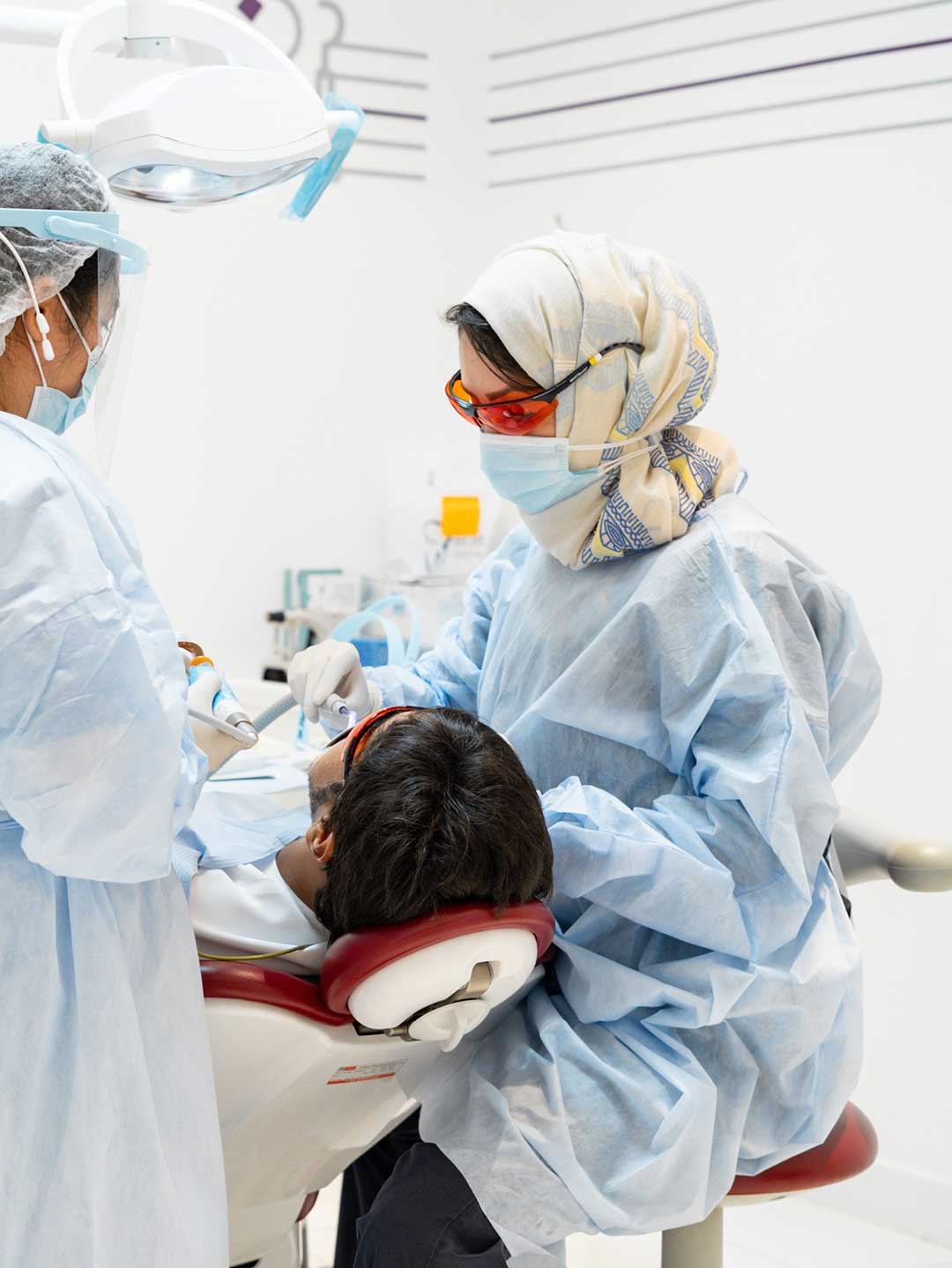A general dentist at Harmony Medical Center examines patient's mouth checking for cavities or the need for dental fillings.