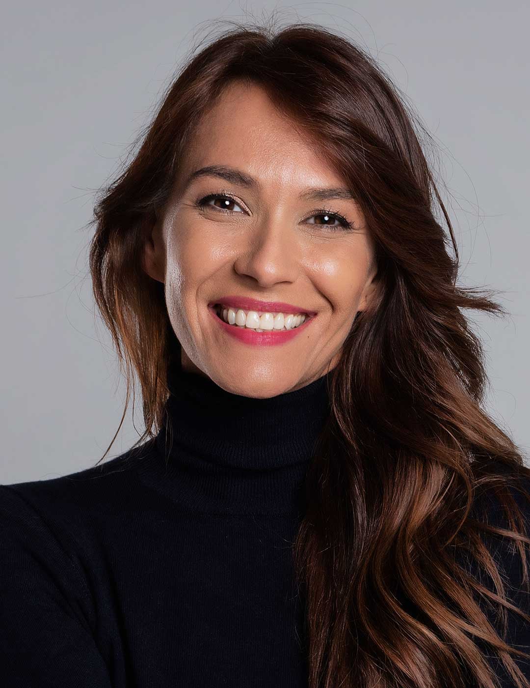 Portrait of a confident woman smiling with natural-looking veneers.