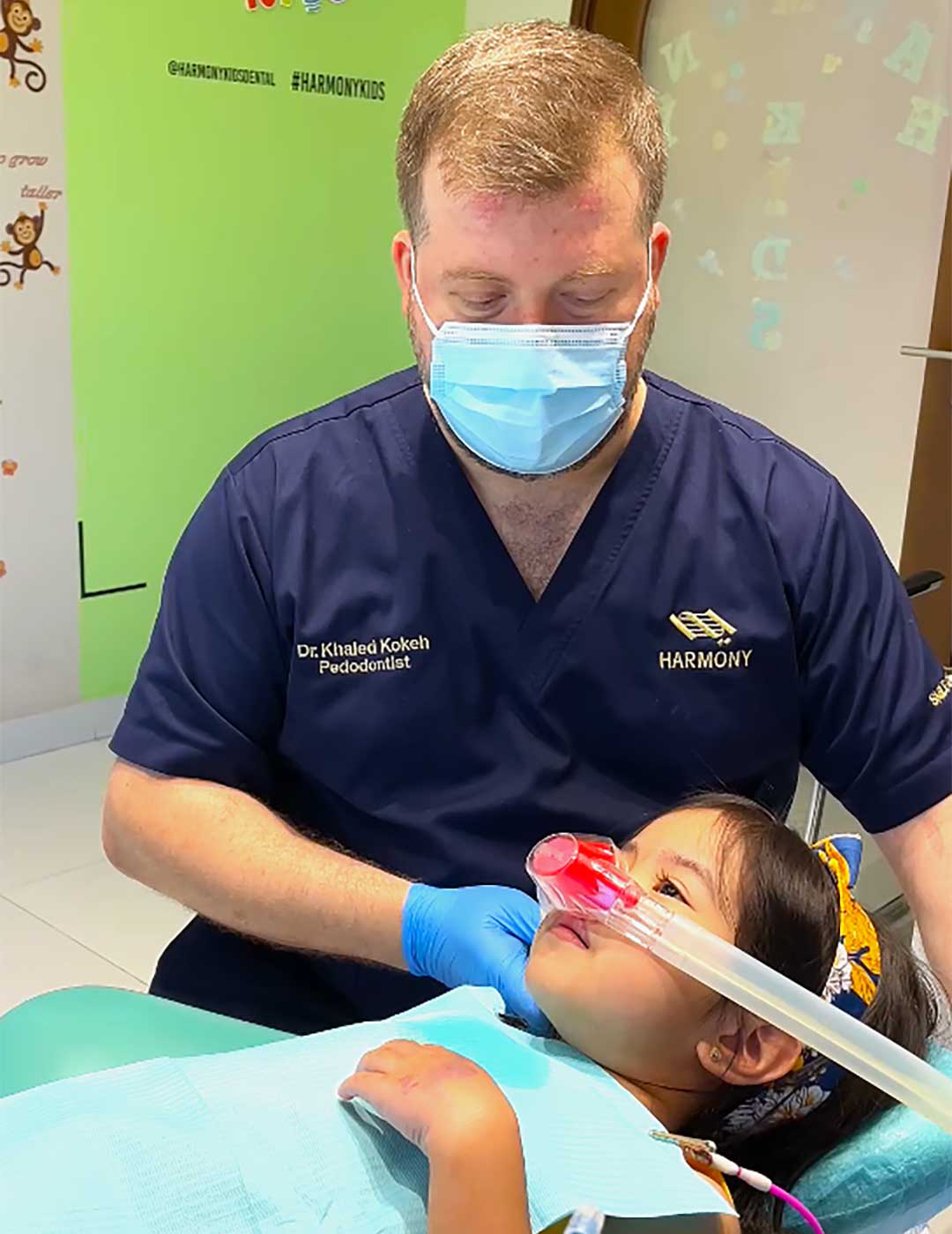 Dr. Khaled Kokeh, pediatric dentist at Harmony, performing dental treatment on a young patient under laughing gas sedation.